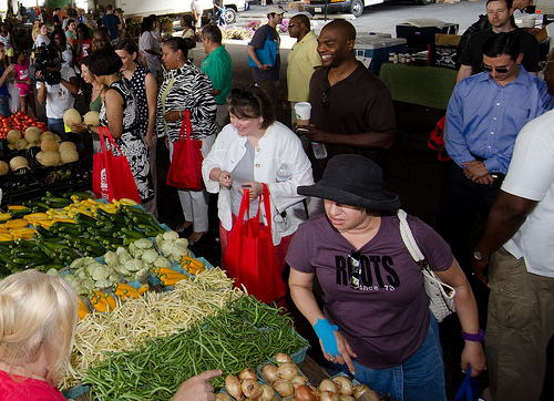 USDA Deputy Secretary Kathleen Merrigan (center, white jacket) buys produce during a July trip to visit the Baltimore farmers market in Maryland.  The mid-Atlantic region saw double-digit growth in its listings in the National Farmers Market Directory.  Maryland added 76 new market listings alone. USDA Photo by Lance Cheung.