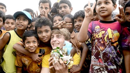 Filip posing with Bangladeshi children whle picking up garbage.