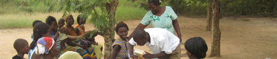 A mother waits while vaccine is drawn for her child at a field clinic in Ghana.