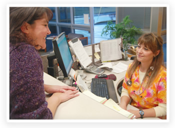 A patient is helped at the front desk of a small clinic