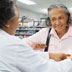 An older woman speaks with a pharmacist about a prescription
