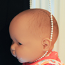 cord around a baby doll's neck