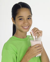 Girl drinking a glass of milk.