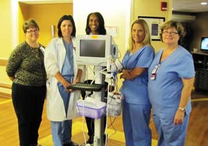 Photo of VA nurses standing in front of a ECG Waveform Tip Confirmation machine