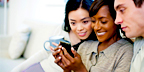 2 women and 1 man using a smartphone together - happy (diverse races)