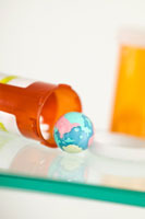 Photo: Bottle of pills with miniature globe