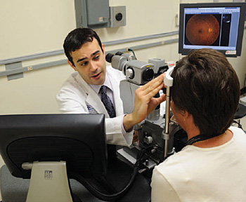 Doctor examining a patients eyes through a machine.