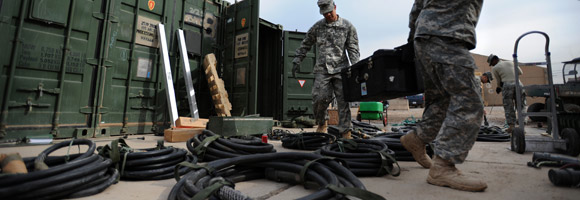 Service members moving equipment