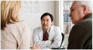 An image of a male health professional speaking with older male and female patients