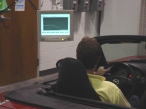 Foto: Conductor mirando una pantalla de la computadora que muestra la prueba estipulada y estadísticas de manejo