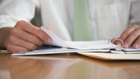 Image of a person flipping through pages in a book.