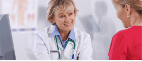 A smiling female professional speaking to a woman.