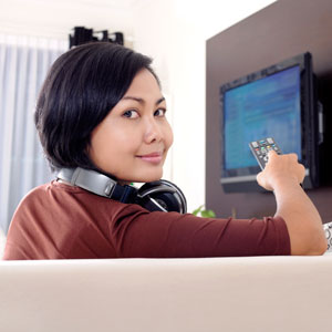 Photograph of a young woman watching television.