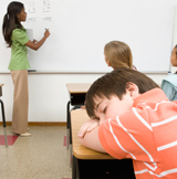 Boy falling asleep as teaching is presenting.