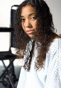 A teen girl in a hospital gown.