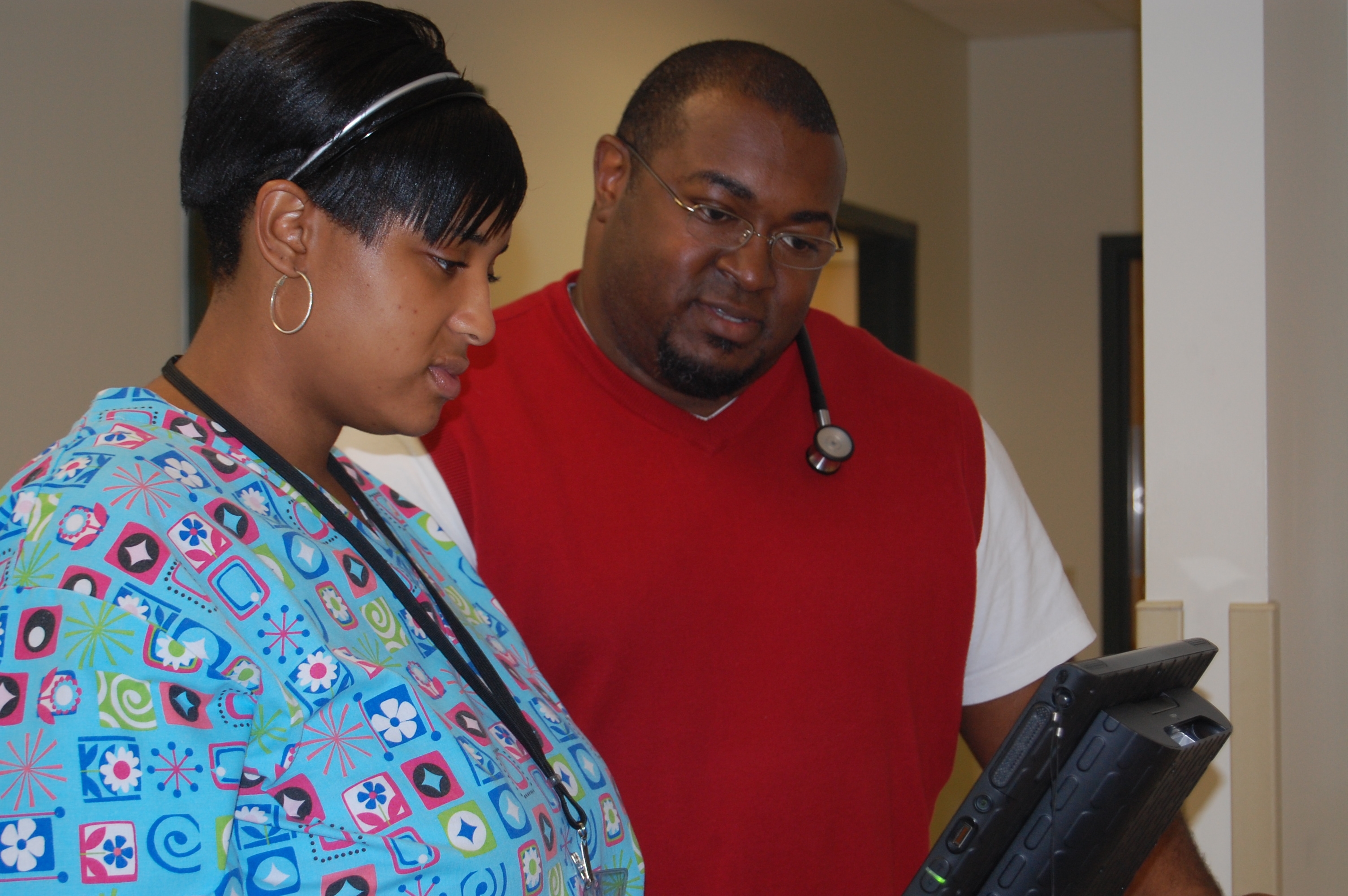 Image Dereck Davis looking at a computer monitor with a nurse