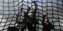 Soldiers climbing cargo net obstacle