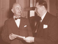 On September 9, 1947, FDIC Chairman Maple Harl (right) presented to Under Secretary of the Treasury A.L.M. Wiggins a check for $146 million, repaying more than half of the government's initial funding of the FDIC.  The balance was repaid in 1948.