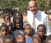 Fogarty Director Dr Roger I Glass with a large group of African children, posing for camera