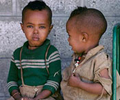 Photo by Ray Witlin/World Bank, Two young boys seated, one looks at camera with swollen infected eye