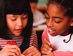 Girls helping each other read