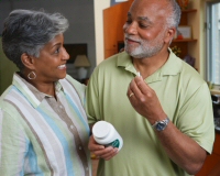 A couple holding a dietary supplement pill