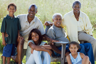 A family sits together in the grass.