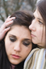 Woman with arm around girl who is crying