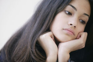 Photograph of a young woman looking thoughtful.
