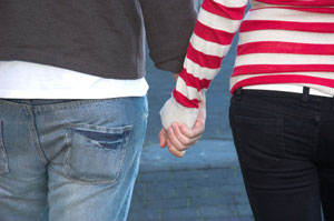 Photograph of two teens holding hands.