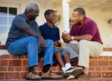 Photograph of three generations of men talking