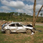 image of a car smashed into a tree, the result of tornado damage. Photo courtesy of the Georgia Emergency Management Agency