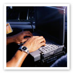 Image of police officer typing on computer in car