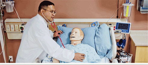 A nursing student practicing on a mannequin.
