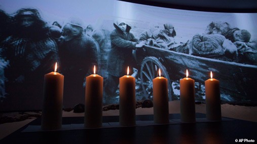 Memorial candles are lit in front of a photo taken during WWII showing refugees fleeing from the Nazis at a ceremony marking International Holocaust Remembrance Day in Russia's first Jewish Museum in Moscow, Russia, Jan. 27, 2013. [AP Photo]