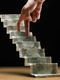 Photograph of a dollar bill folded into steps, with fingers "walking" up the steps.