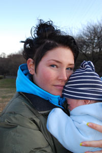 Photograph of a teen girl holding a baby.