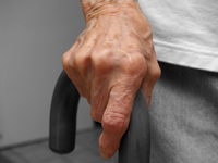 A man's hand is resting on a cane