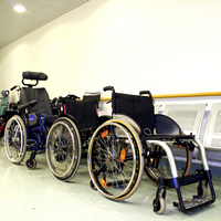 Three different kiinds of wheelchairs lined up in a row