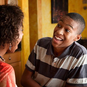 Photograph of a young man talking with a youth worker.