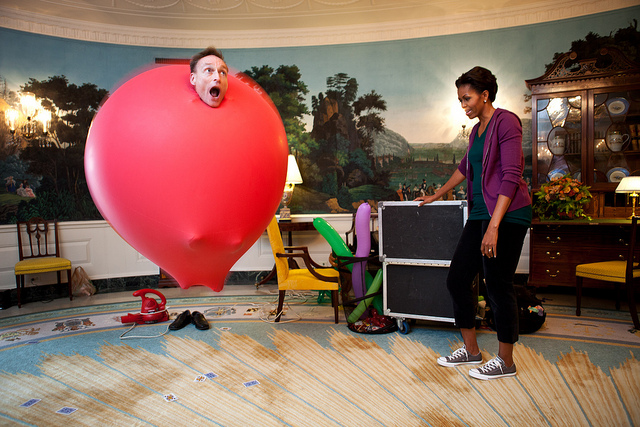 Image description: Guinness Book of World Records holder John Cassidy performs a balloon act for First Lady Michelle Obama in the Diplomatic Reception Room of the White House. Cassidy performed for kids on the South Lawn before the First Lady launched a challenge to break the Guinness World Records title for the most people doing jumping jacks in a 24-hour period.
Official White House photo by Chuck Kennedy