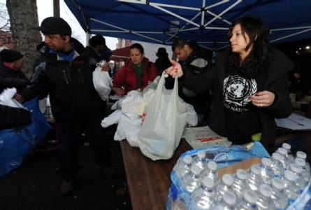 Volunteers work together to bag food and supplies for residents affected by a disaster.