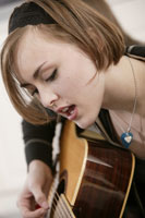 Girl playing a guitar.