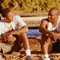 two young men sitting on bleachers talking