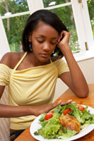 Girl pushing away a plate of food.