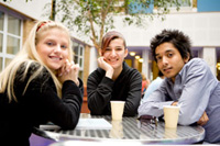 Two boys and a girl sitting around a table.