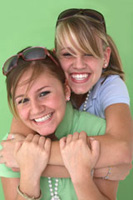 Two girls smiling and embracing.