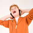 Boy with headphones on screaming.