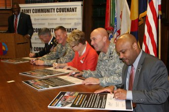 FORT CARSON, Colo. -- From right, Denver Mayor Michael B. Hancock; Maj. Gen. Joseph Anderson, commanding general, 4th Infantry Division and Fort Carson; Mary Beth Susman, president, Denver City Council; Garrison Commander Col. David Grosso; and Command Sgt. Maj. William D. Woods, 89th Troop ^Command, Colorado National Guard; sign the Army Community Covenant between Fort Carson and the city of Denver, Jan. 25 in the Denver City and County Building. Terrance McWilliams, left, director of military support for the El Pomar Foundation, was the ceremony emcee.