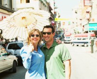 Foto de un hombre y una mujer con gafas de sol sosteniendo un parasol